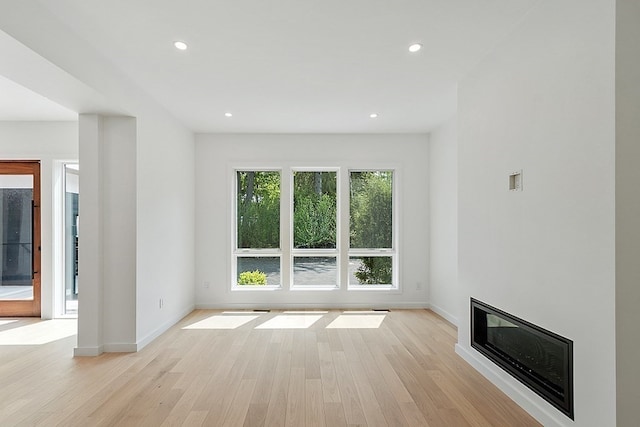 unfurnished room featuring light wood-type flooring and a healthy amount of sunlight