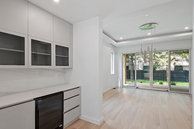 kitchen featuring a healthy amount of sunlight, decorative light fixtures, light hardwood / wood-style flooring, and white cabinetry