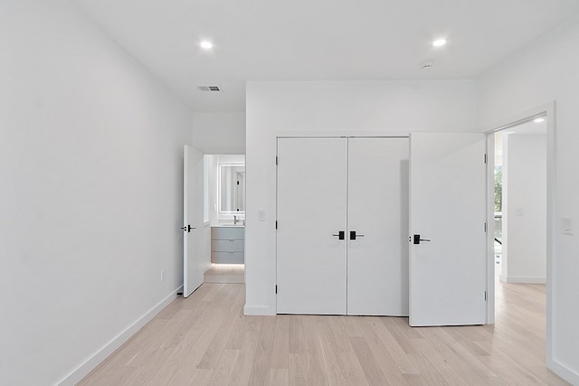 unfurnished bedroom with a closet and light hardwood / wood-style flooring