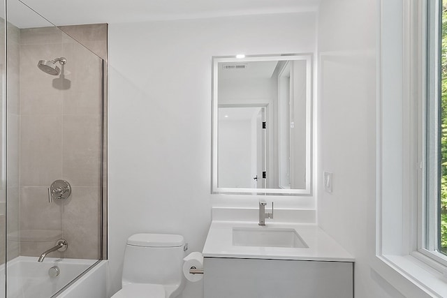 full bathroom featuring toilet, shower / bath combination with glass door, and vanity