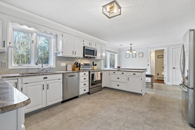 kitchen featuring white cabinetry, kitchen peninsula, sink, and appliances with stainless steel finishes