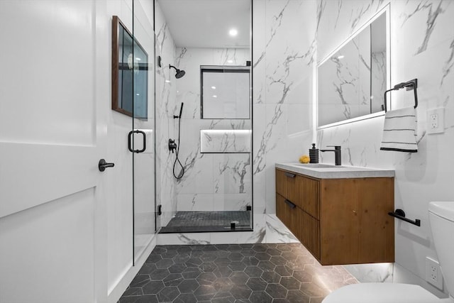 full bathroom with a marble finish shower, vanity, and toilet