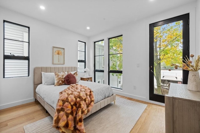 bedroom with light wood-type flooring, access to exterior, baseboards, and recessed lighting