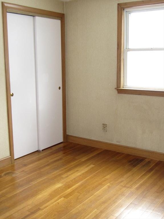 unfurnished bedroom with a closet and light hardwood / wood-style flooring