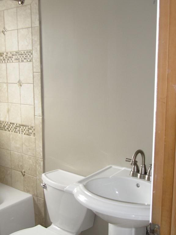 full bathroom featuring sink, toilet, and tiled shower / bath combo