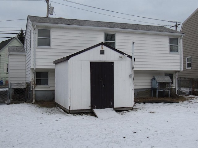 view of snow covered back of property