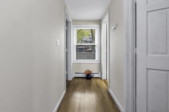 hallway featuring baseboards, dark wood finished floors, and a baseboard heating unit