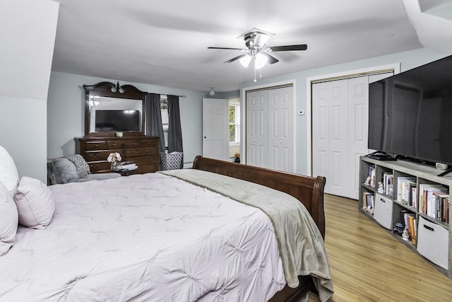 bedroom with multiple closets, light wood-type flooring, and a ceiling fan