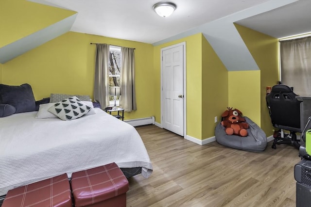bedroom with wood finished floors, a baseboard heating unit, baseboards, and lofted ceiling