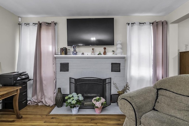 living room with wood finished floors and a fireplace with flush hearth