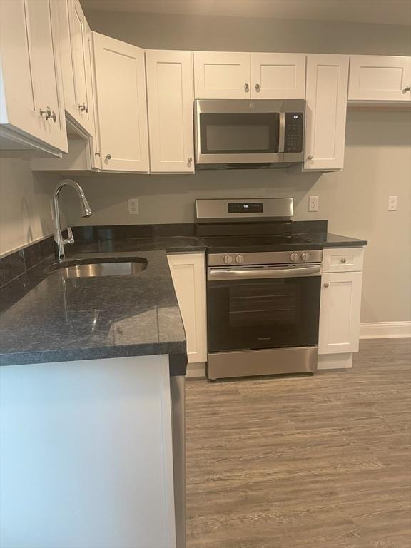 15 Forest St, Whitman, MA 02382 - kitchen featuring appliances with stainless steel finishes, a sink, and white cabinetry