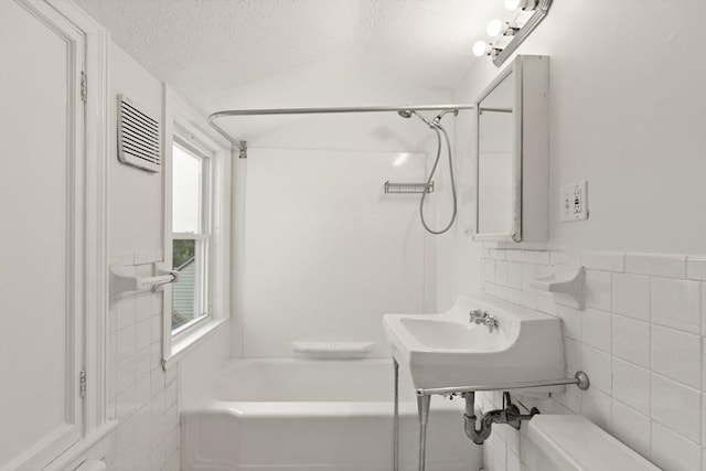 36 Kings Bch, Swampscott, MA 01907 - bathroom featuring tile walls, toilet, a textured ceiling, and  shower combination