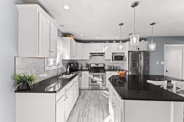 kitchen with a sink, tasteful backsplash, a center island, white cabinetry, and stainless steel appliances