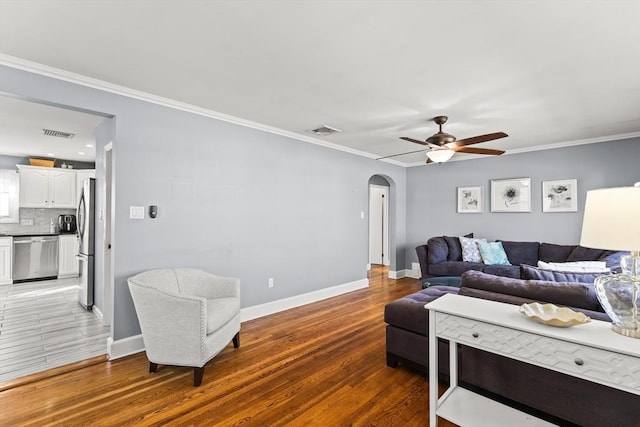 living area featuring light wood-style flooring, arched walkways, and visible vents