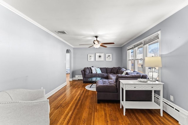 living area with visible vents, arched walkways, wood finished floors, and crown molding