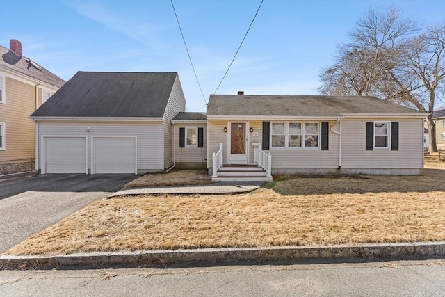 single story home with aphalt driveway and an attached garage