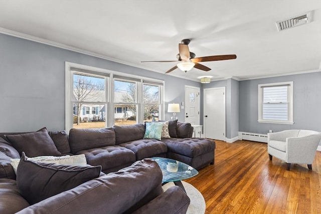 living room with wood finished floors, visible vents, ceiling fan, crown molding, and baseboard heating