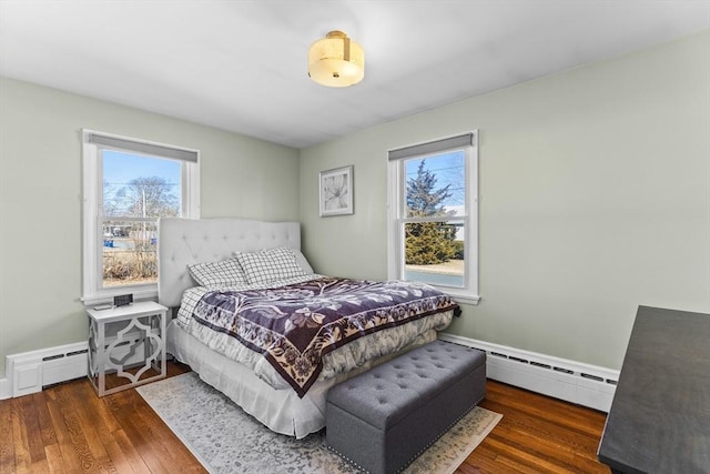 bedroom featuring a baseboard radiator, baseboards, and hardwood / wood-style flooring