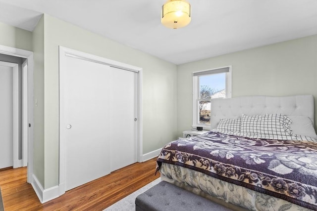 bedroom with a closet, baseboards, and wood finished floors