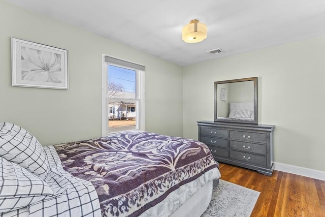 bedroom with dark wood-type flooring, visible vents, and baseboards