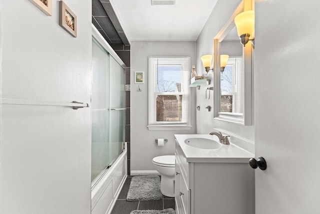 full bath with visible vents, toilet, baseboards, enclosed tub / shower combo, and vanity