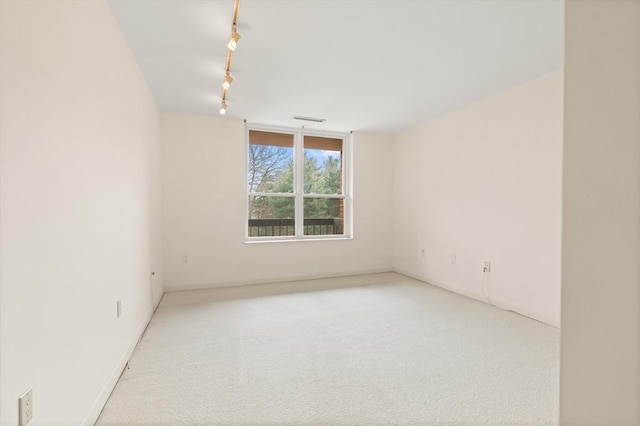 carpeted spare room featuring visible vents and rail lighting