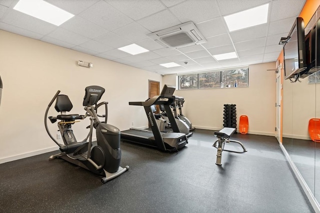 exercise room featuring a drop ceiling and baseboards