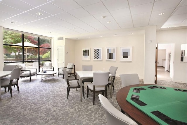 dining space featuring visible vents, a drop ceiling, expansive windows, carpet flooring, and recessed lighting