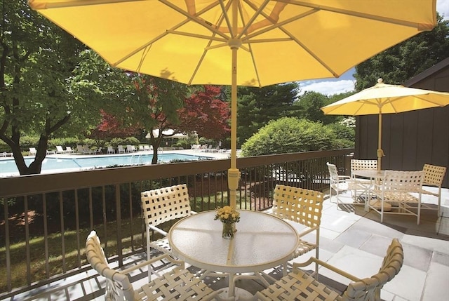 view of patio featuring outdoor dining space and a community pool