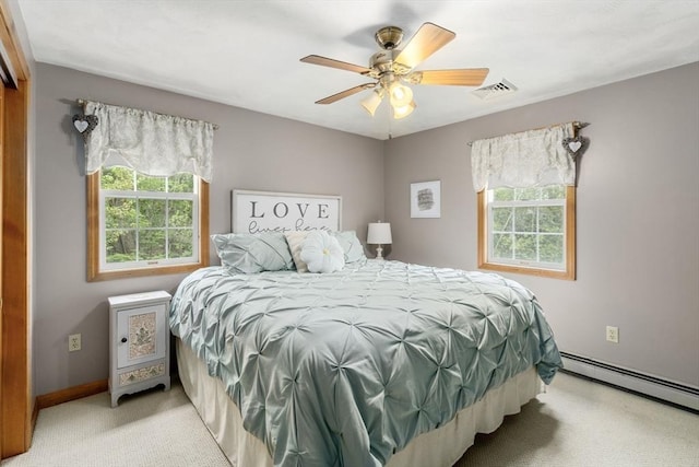 bedroom with light colored carpet, baseboard heating, a ceiling fan, and baseboards