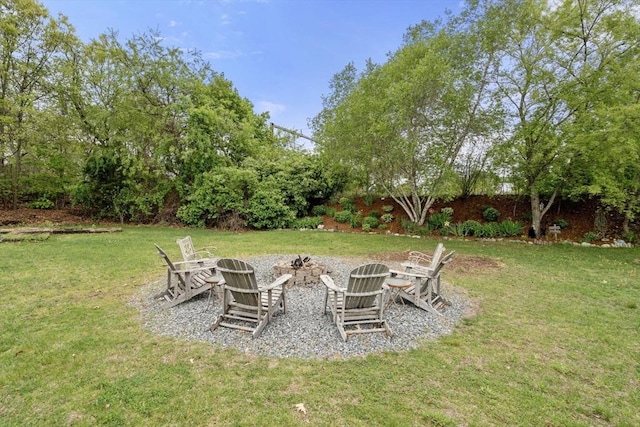 view of green lawn with an outdoor fire pit