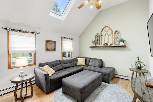 living area with a baseboard heating unit, lofted ceiling, a ceiling fan, wood finished floors, and a skylight
