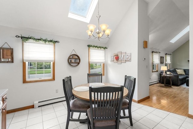 dining space with a baseboard radiator, a skylight, healthy amount of natural light, a chandelier, and high vaulted ceiling