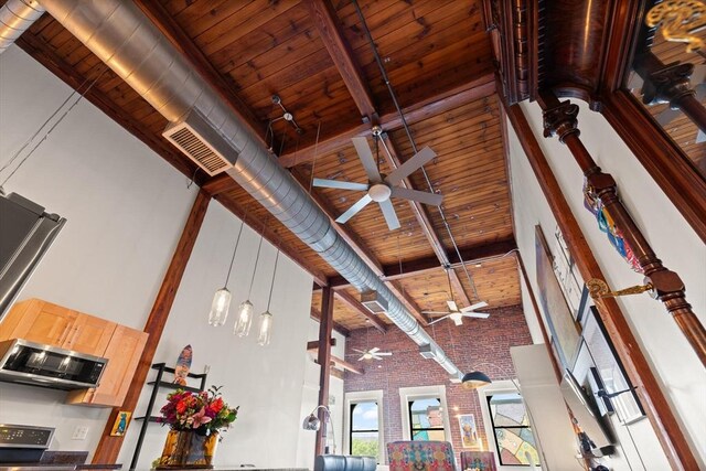 49 Munroe St Unit 405, Lynn, MA 01901 - detailed view of ceiling fan, brick wall, a wood ceiling with exposed beams, stainless steel microwave, and stove