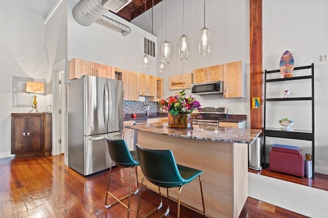 49 Munroe St Unit 405, Lynn, MA 01901 - kitchen with appliances with stainless steel finishes, a high ceiling, light brown cabinetry, dark wood-style flooring, and a kitchen island