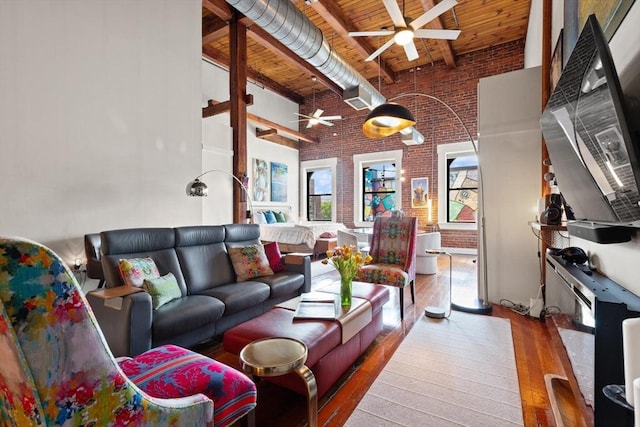 49 Munroe St Unit 405, Lynn, MA 01901 - living area featuring a ceiling fan, a wooden ceiling with exposed beams, a towering ceiling, brick wall, and hardwood / wood-style flooring