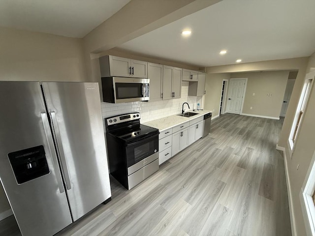kitchen with appliances with stainless steel finishes, a sink, recessed lighting, decorative backsplash, and baseboards
