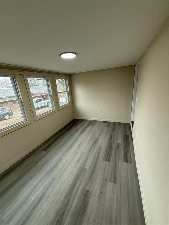 spare room with wood finished floors and baseboards