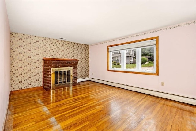 49 Whitman St, Weymouth, MA 02189 - unfurnished living room with a baseboard heating unit, wallpapered walls, hardwood / wood-style flooring, a brick fireplace, and baseboards