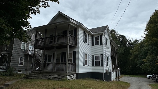 view of front of house with a balcony and a front lawn