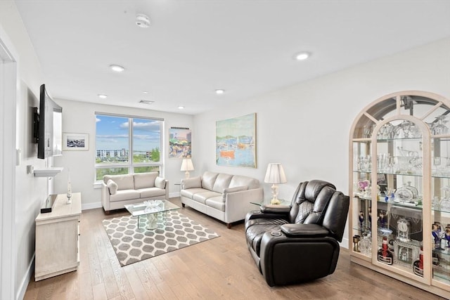 living area featuring wood finished floors, baseboards, and recessed lighting