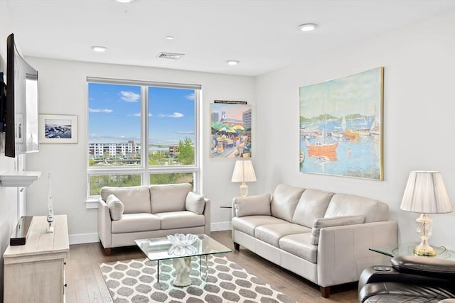 living room featuring hardwood / wood-style floors, baseboards, and recessed lighting