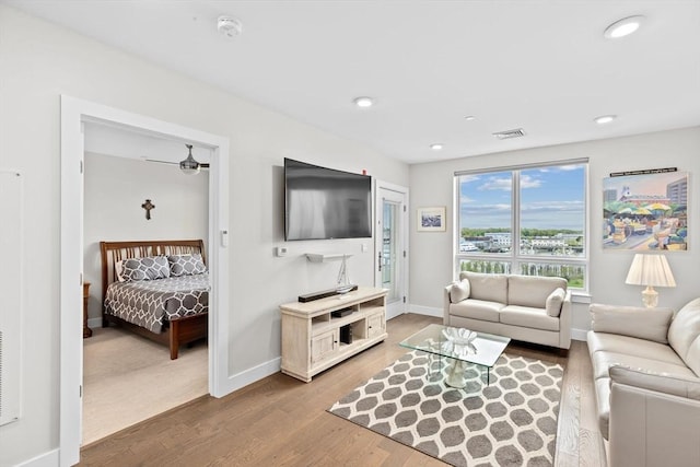 living room with wood finished floors, baseboards, and recessed lighting