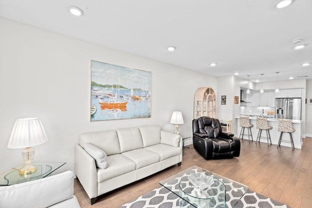 living area with light wood-style floors, recessed lighting, and baseboards