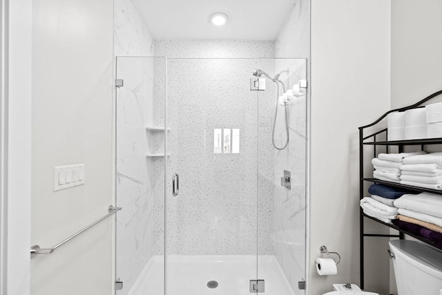 full bath with toilet and a marble finish shower