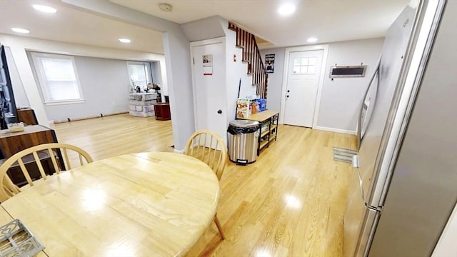 dining room with light wood-style flooring, recessed lighting, stairs, plenty of natural light, and baseboards
