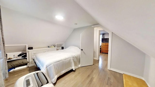 bedroom featuring light wood-style floors and vaulted ceiling
