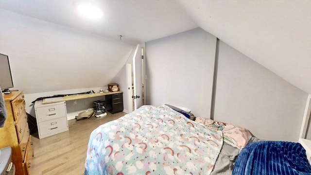 bedroom with vaulted ceiling and wood finished floors