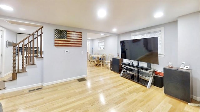 living area featuring stairs, wood finished floors, baseboards, and recessed lighting