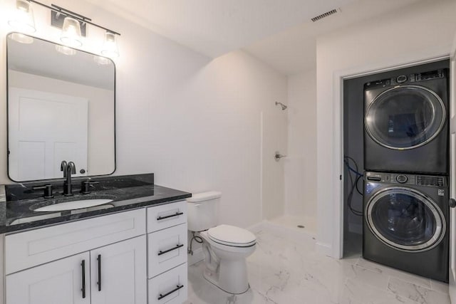 14 Jackson Ln, Barre, MA 01005 - bathroom featuring stacked washer and clothes dryer, marble look tile flooring, a shower, toilet, and vanity